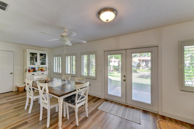 dining area with french doors, light hardwood / wood-style flooring, ceiling fan, and a healthy amount of sunlight