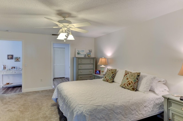 bedroom featuring carpet flooring, ceiling fan, a textured ceiling, and a closet