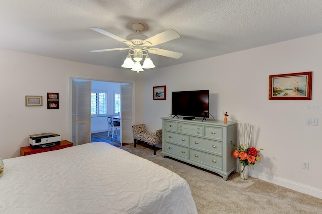 carpeted bedroom featuring a textured ceiling and ceiling fan