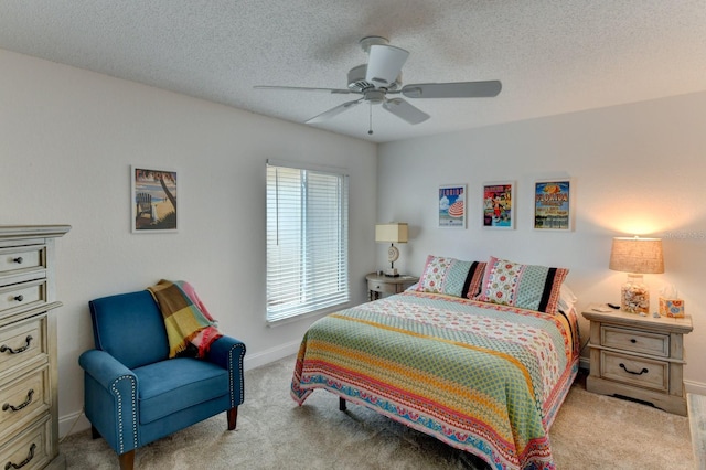 bedroom with ceiling fan, light carpet, and a textured ceiling