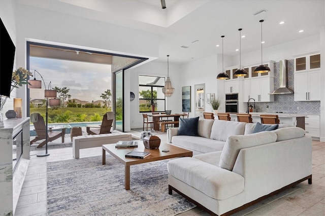 living room featuring sink, a wealth of natural light, and a high ceiling