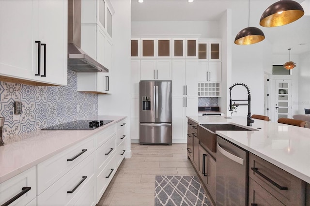 kitchen with white cabinets, stainless steel appliances, and wall chimney exhaust hood