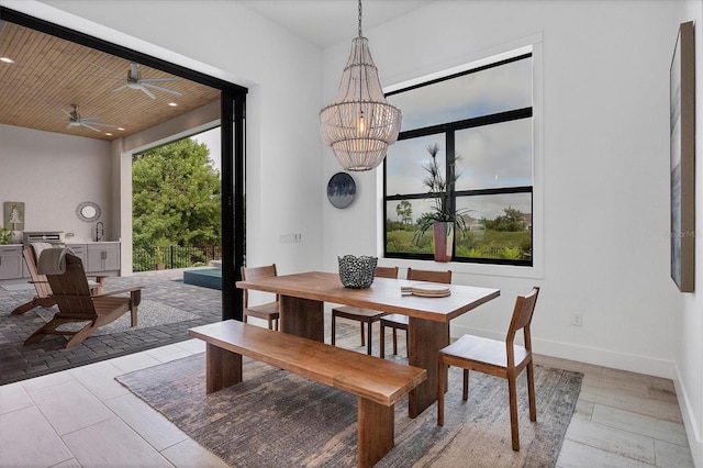 dining area featuring ceiling fan with notable chandelier, light hardwood / wood-style floors, and wooden ceiling