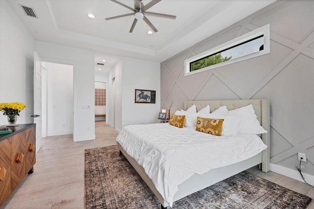 bedroom with a tray ceiling and ceiling fan