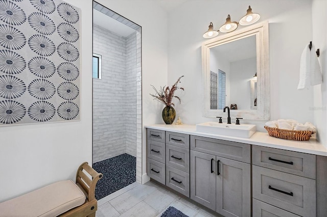 bathroom featuring tiled shower and vanity