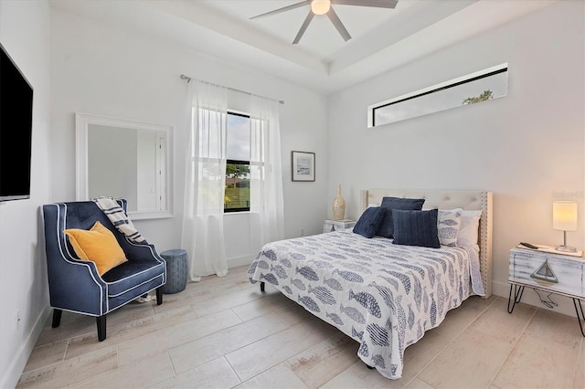 bedroom with ceiling fan and a raised ceiling