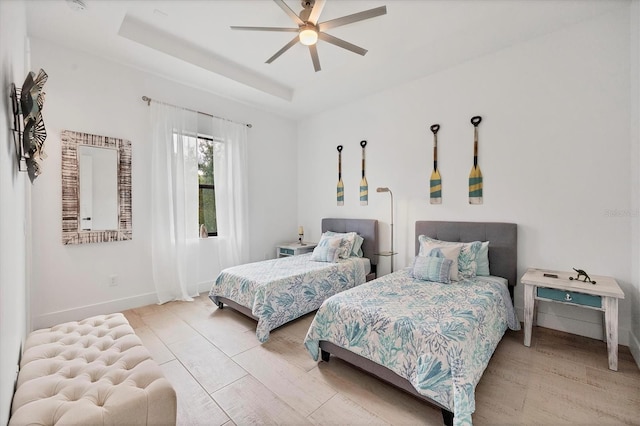 bedroom featuring a raised ceiling and ceiling fan