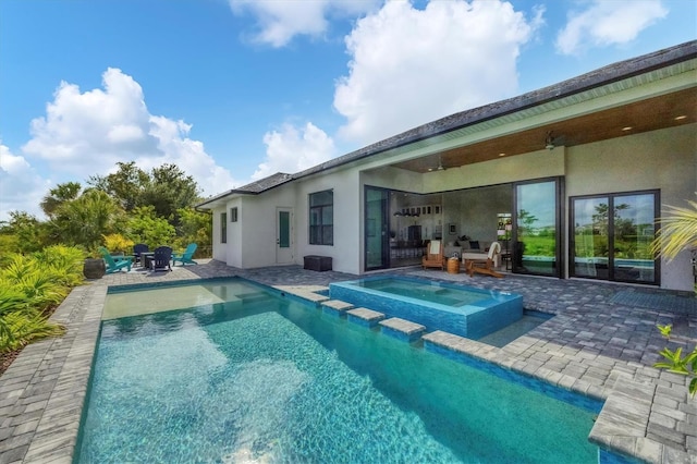 view of pool featuring a patio area and an in ground hot tub