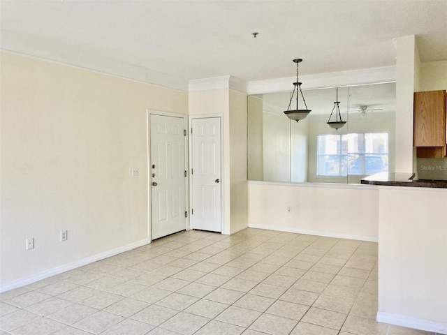 empty room featuring ceiling fan, ornamental molding, and light tile patterned floors