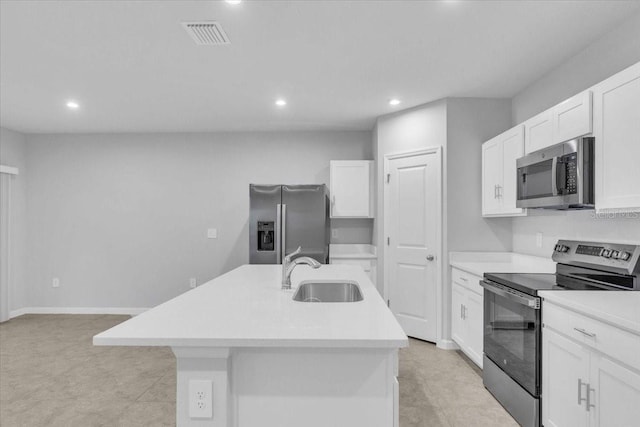 kitchen with sink, white cabinets, appliances with stainless steel finishes, and a kitchen island with sink