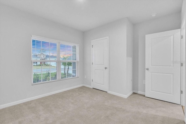 unfurnished bedroom with light colored carpet