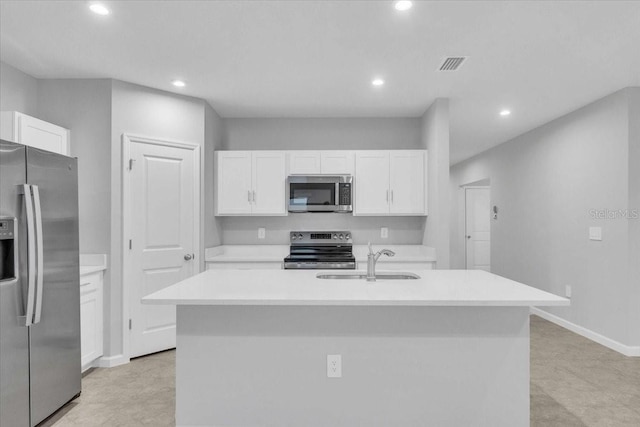 kitchen with sink, white cabinetry, appliances with stainless steel finishes, and an island with sink