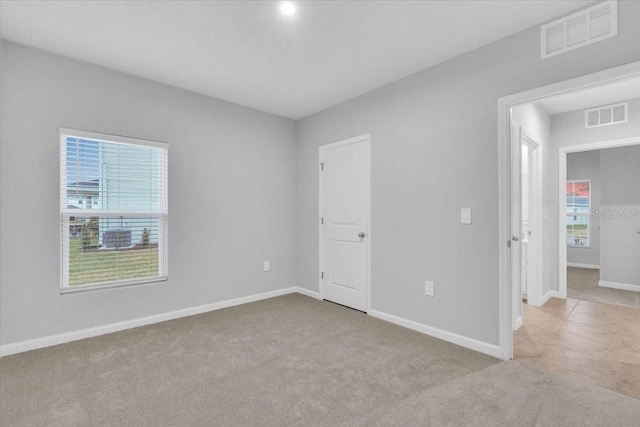 carpeted spare room featuring plenty of natural light