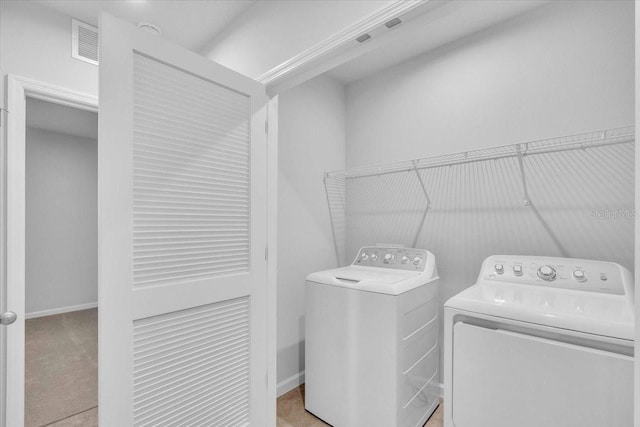 clothes washing area with washing machine and dryer