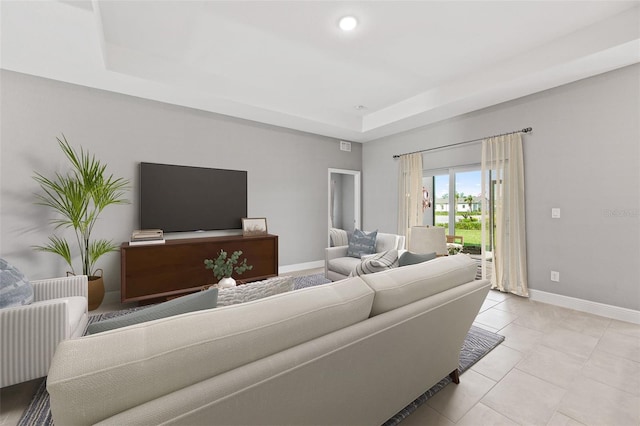 tiled living room featuring a raised ceiling