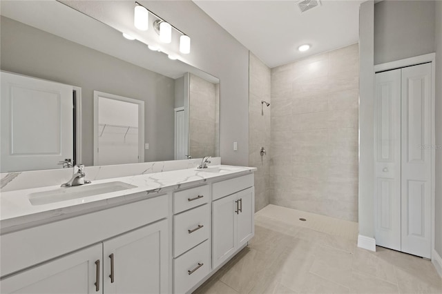 bathroom featuring tile patterned floors, vanity, and tiled shower