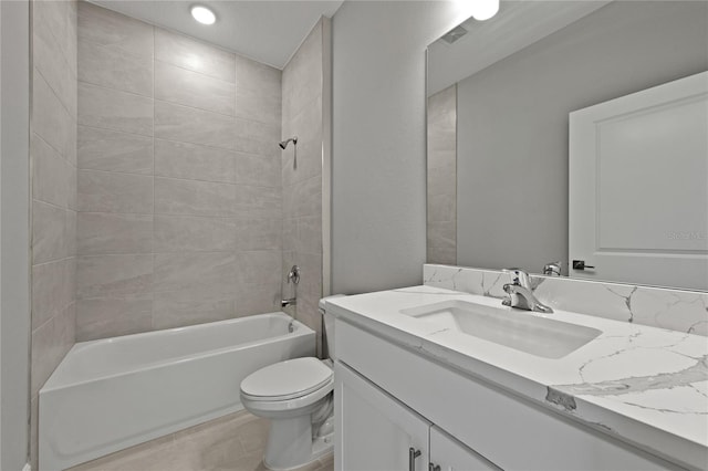 full bathroom featuring tile patterned flooring, vanity, toilet, and tiled shower / bath