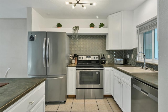 kitchen featuring sink, light tile patterned flooring, decorative backsplash, white cabinets, and appliances with stainless steel finishes