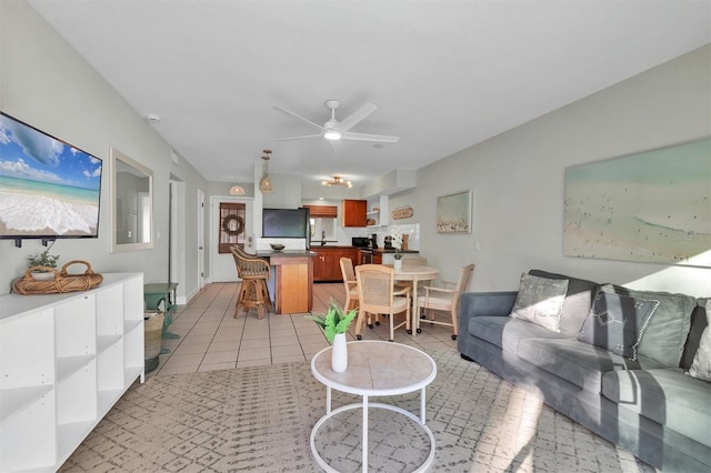 tiled living room with ceiling fan and sink