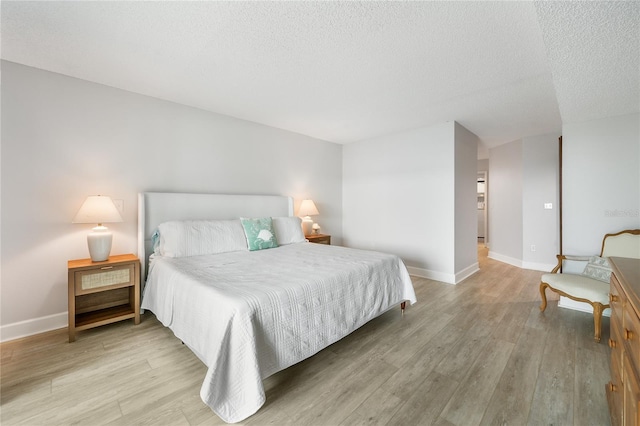 bedroom featuring a textured ceiling and light hardwood / wood-style floors