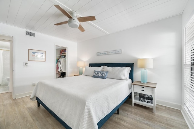 bedroom with a walk in closet, ensuite bath, light hardwood / wood-style flooring, ceiling fan, and a closet