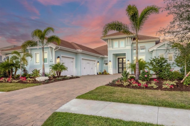 view of front of property with a lawn, french doors, and a garage