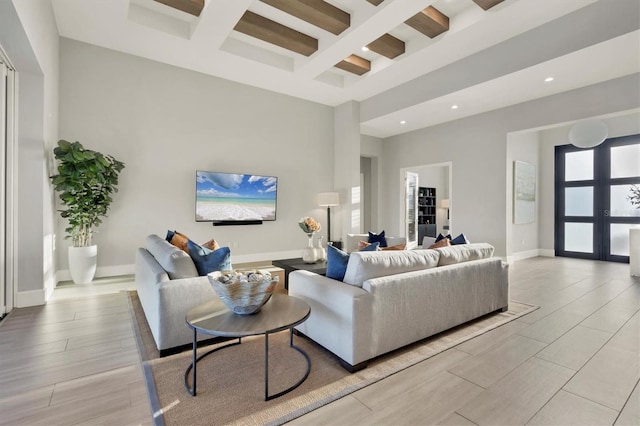 living room with beam ceiling, a towering ceiling, and coffered ceiling