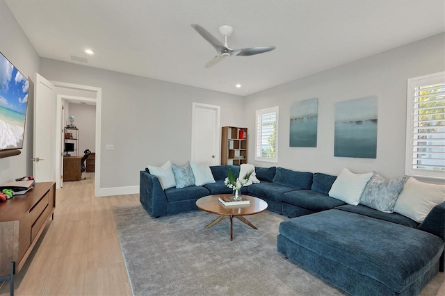 living room with a wealth of natural light, ceiling fan, and light hardwood / wood-style floors