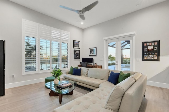 living room featuring ceiling fan, light wood-type flooring, and french doors