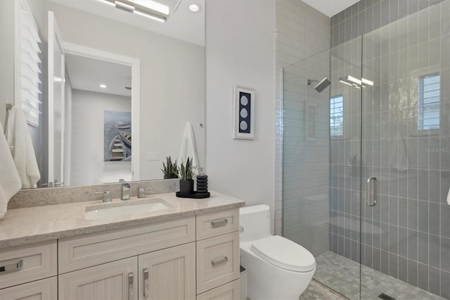 bathroom featuring vanity, an enclosed shower, and toilet