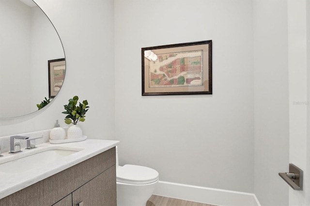 bathroom featuring hardwood / wood-style floors, vanity, and toilet