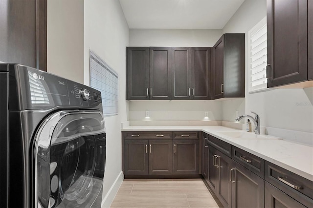 laundry area featuring cabinets, washer / dryer, and sink