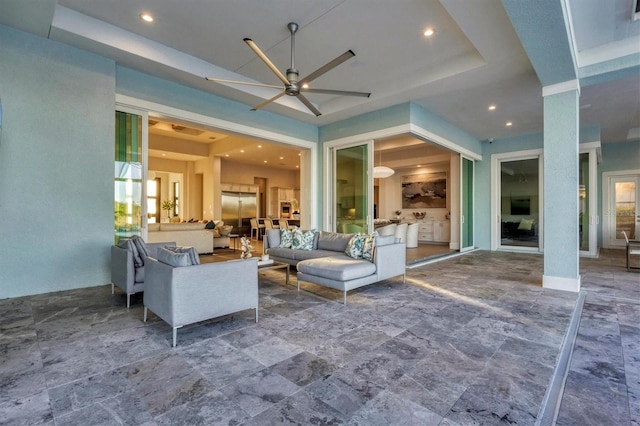 interior space with a raised ceiling and ceiling fan