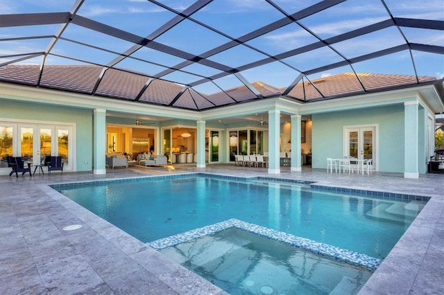 view of pool featuring french doors, glass enclosure, ceiling fan, and a patio area