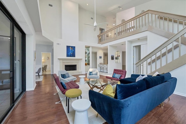 living room featuring ceiling fan, dark hardwood / wood-style flooring, and a high ceiling