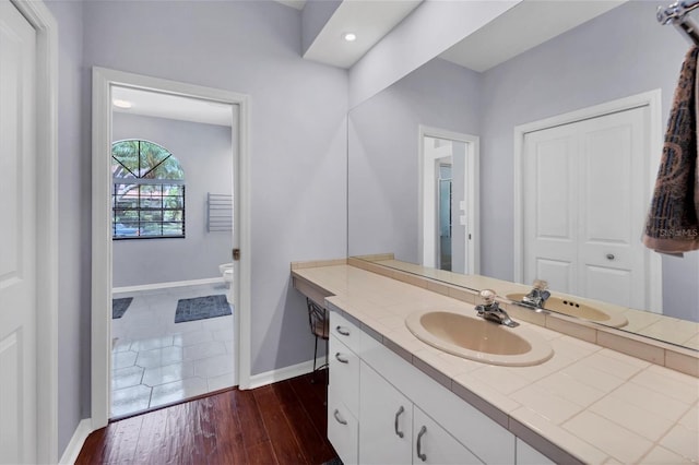 bathroom featuring vanity, wood-type flooring, and toilet