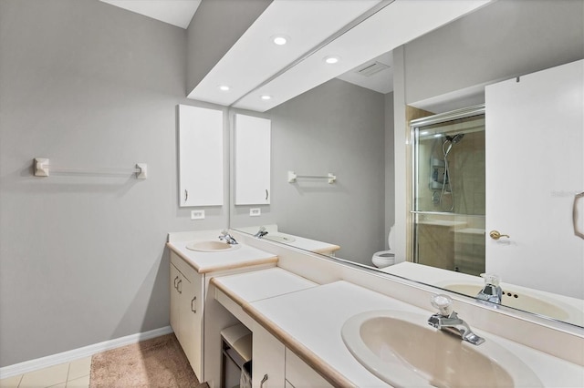 bathroom featuring tile patterned floors, vanity, an enclosed shower, and toilet