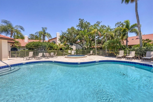 view of swimming pool featuring a patio area and a hot tub