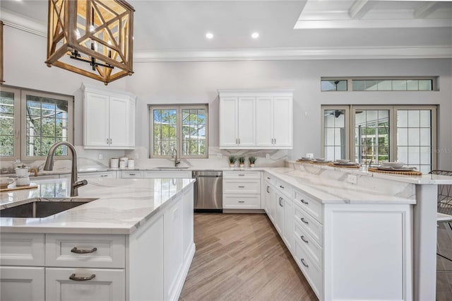 kitchen with light stone countertops, dishwasher, sink, pendant lighting, and a breakfast bar area