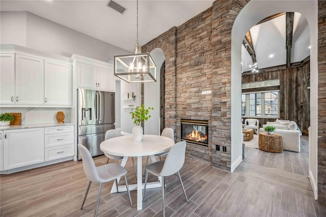 dining area with wood walls, a fireplace, and light wood-type flooring