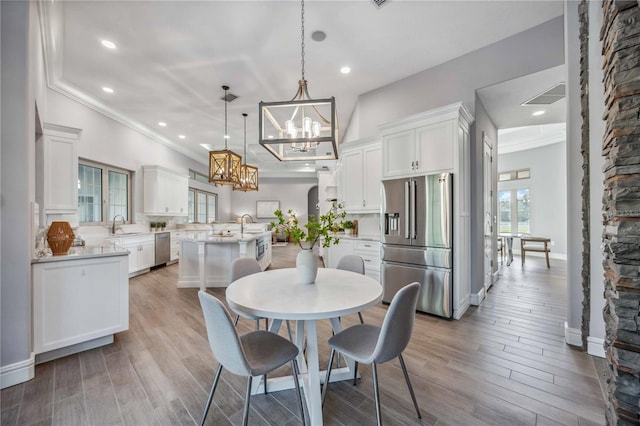 dining room featuring sink, crown molding, and an inviting chandelier