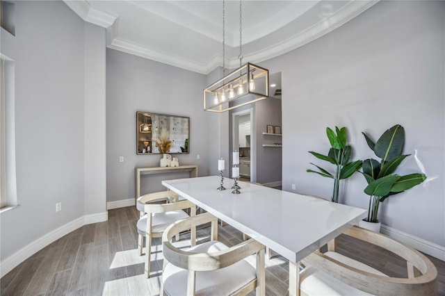 dining area featuring crown molding, light hardwood / wood-style flooring, and an inviting chandelier