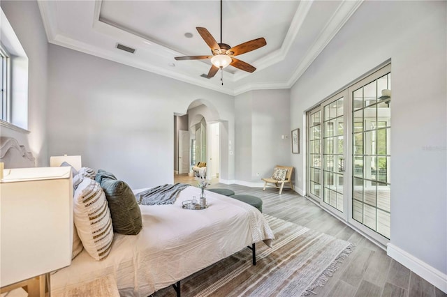 bedroom with access to exterior, a raised ceiling, ceiling fan, crown molding, and hardwood / wood-style floors