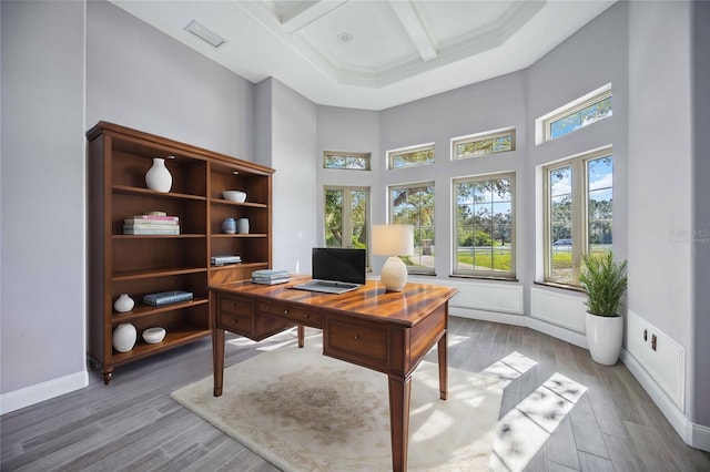 office featuring beam ceiling, hardwood / wood-style floors, a towering ceiling, and coffered ceiling