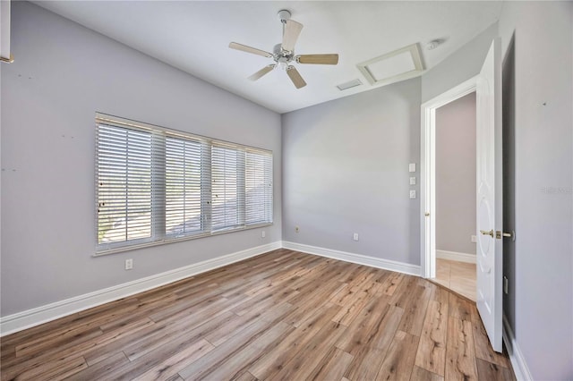 spare room with ceiling fan and light wood-type flooring