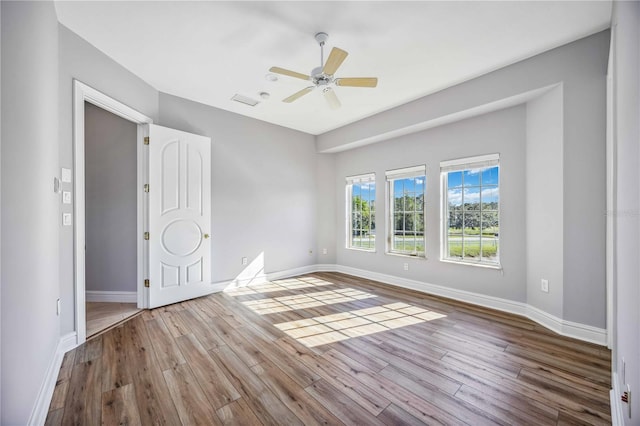 empty room with ceiling fan and hardwood / wood-style floors