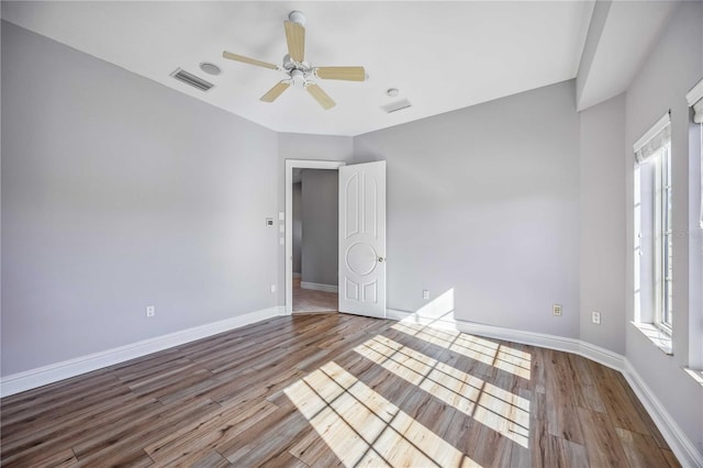 empty room with ceiling fan, light hardwood / wood-style flooring, and a healthy amount of sunlight