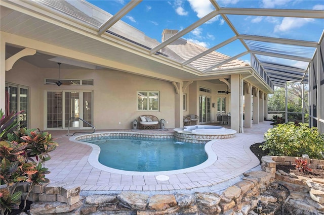 view of swimming pool with french doors, ceiling fan, a lanai, an in ground hot tub, and a patio