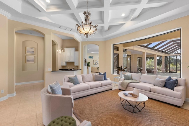 tiled living room featuring beam ceiling, a towering ceiling, coffered ceiling, ornamental molding, and a chandelier