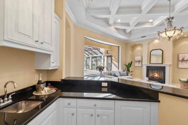 kitchen with coffered ceiling, sink, white cabinetry, crown molding, and beamed ceiling